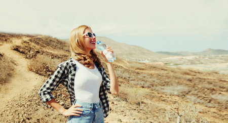 Portrait of happy young woman with bottle of water on hiking trail on top of the mountain, Tenerife, Canary Islands, Spainの写真素材