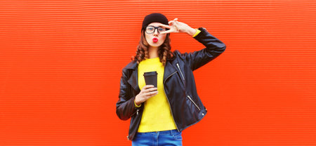 Portrait of stylish woman model posing and blowing her lips sends kiss wearing black rock style...