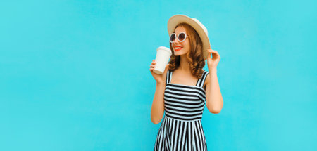 Portrait of happy smiling young woman drinking fresh juice or coffee wearing summer straw hat, dress...
