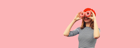 Portrait of happy funny smiling woman covering her eyes looking for something looking through donuts...