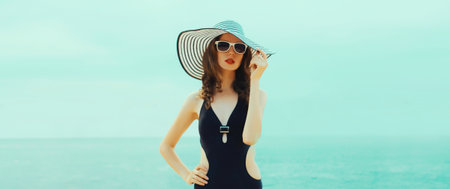 Summer vacation, beautiful young woman in bikini swimsuit and straw hat on the beach on sea coast...