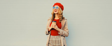 Autumn style outfit, stylish happy smiling young woman model with cup of coffee wearing red french...