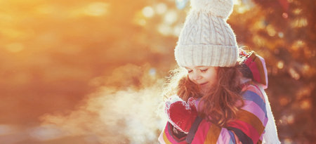 Winter portrait of happy smiling little girl child outdoors on snowy background