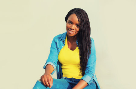 Portrait of stylish young african woman with dreadlocks posing wearing casual in the city