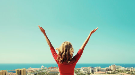 Summer vacation, beautiful happy young woman tourist raising her hands up on top of the mountain looking around the city in Tenerife, Canary Islands, Spain. Aerial top view.の写真素材