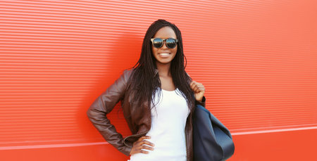 Fashionable happy young African woman with handbag in casual clothing, stylish modern black girl...