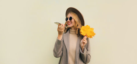 Autumn portrait of happy smiling young woman calling on phone, stylish girl talking on the...