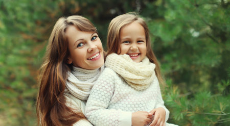 Portrait of happy joyful mother and little girl child together laughing near Christmas tree in...