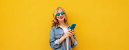 Summer happy young woman with phone, modern smiling girl holding smartphone in casual denim clothing...