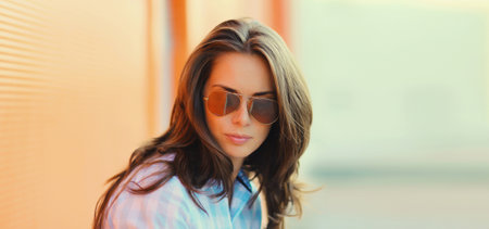 Portrait of beautiful brunette young woman in sunglasses posing in the city