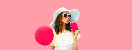 Portrait of beautiful young woman model with cup of coffee or fresh juice holding balloon wearing...