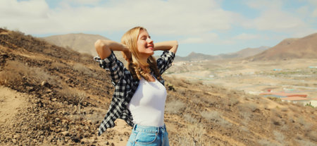 Happy caucasian young woman on a hiking trail on top of the mountain, Tenerife, Canary Islands, Spainの写真素材