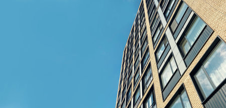 Architecture and real estate, residential apartment building with large panoramic windows, modern complex, blue sky backgroundの写真素材