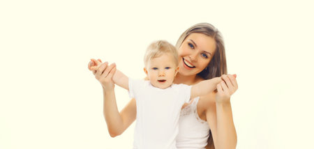 Portrait of happy cheerful smiling mother holding her baby, joyful young mom and little child laughing on white studio backgroundの写真素材