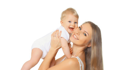 Portrait of happy cheerful smiling mother holding her baby, joyful young mom and little child laughing on white studio backgroundの写真素材