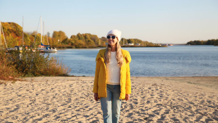 Traveler happy young woman standing on sunny beach looking away, enjoying amazing landscape, warm...