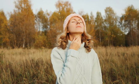 Sick exhausted young woman suffering from acute sore in throat flu, touches her neck with hand, she...