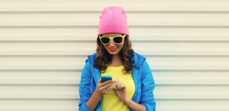 Happy smiling modern young woman with phone, teenage girl holding smartphone looking at device in...