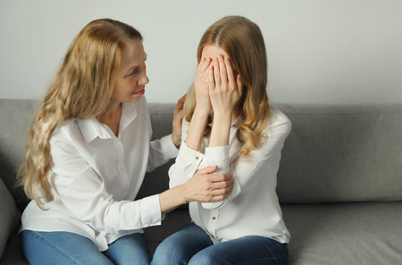 Upset offended caucasian two women, mature mother or sister and adult daughter crying together...