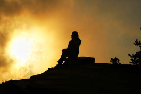 2 march 2020. a girl is sitting  on top of a mountain as the sun sets at hatu peak,himachal  pradesh,india.のeditorial素材