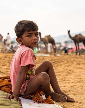 a little rajasthani boy is crying at pushkar camel fair.のeditorial素材