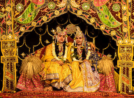 young actor representing krishna and radha marriage on stage with selective focus in subject and added noise and grains.のeditorial素材