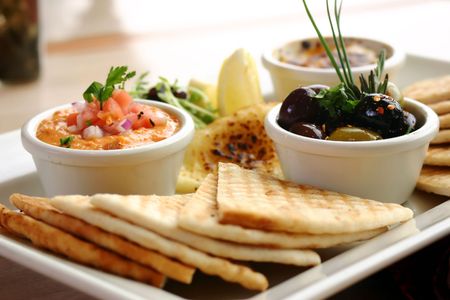 Sumptious platter of flat breads served with red pepper hummus dip, crab dip, olives and grilled haloumi cheese. Shallow DOF.の写真素材