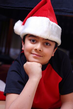 Portrait of a smiling 8 year old boy in a Santa hatの写真素材