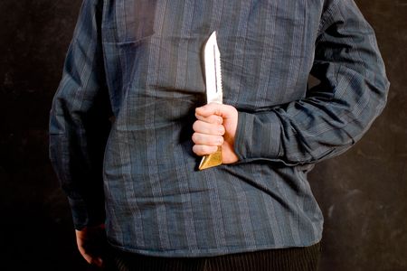 Man with a knife behind his back
