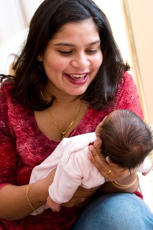A young mother plays with her baby