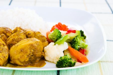 Curried chicken - Caribbean style served with rice and vegetables.  Shallow DOF.の写真素材