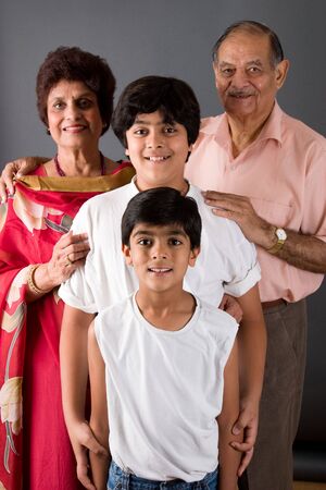 Two children with their grandparents against a gray background