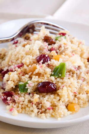 Couscous salad mixed with cranberries, dates, raising, green onions and chickpeas. Topped with dressing made with olive oil, herbs and select spices.の写真素材