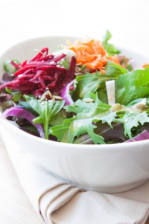 Garden salad made with fresh lettuce, spinach, onions, beets, romaine lettuce and carrots  Drizzled with balsamic vinaigrette の写真素材