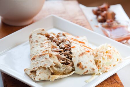 Caribbean style jerk chicken served in traditional roti and drizzled with sweet hot sauce  Served with a side of coleslaw Focus on the chicken の写真素材