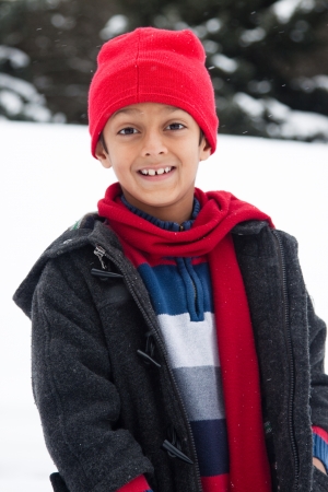 A cute East Indian boy child enjoying the snowfallの写真素材