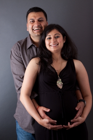 An East Indian couple holding the belly of the pregnant wifeの写真素材