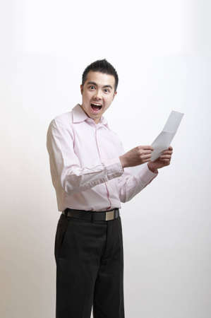 Young Asian man excited by the letter he has just readの写真素材