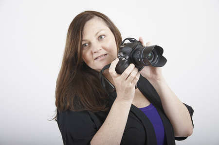 Headshot of a woman holding up a SLR camera
