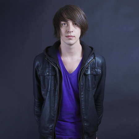 Young man wearing a leather jacket facing the camera