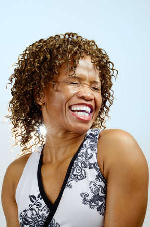 Head and shoulders of a woman laughing with her eyes closedの写真素材