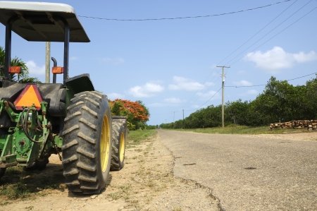 A tractor parked at the side of an empty road viewed from the rear のeditorial素材