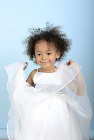 little girl playing with the layers of her dressの写真素材