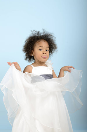 little girl in her formal dress sticking her tongue out in a mocking wayの写真素材