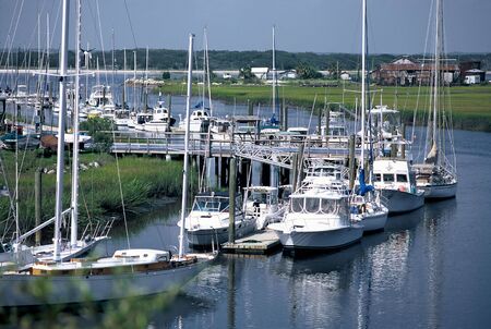 power and sail boat docked on a waterwayの写真素材