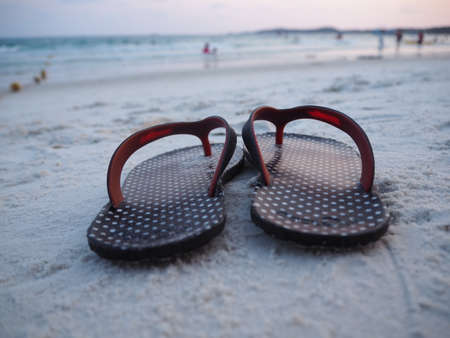 The black flip flops on the beachの写真素材