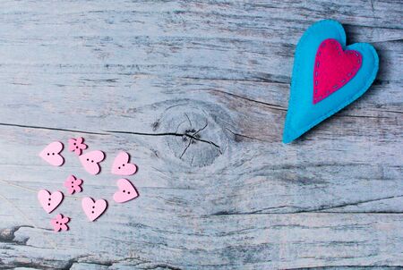 Hand made felt colorful hearts on wooden background. Concept for congratulation, inviting, wedding banner, flyer. Craft element for Valentine's Day, romantic, greeting, love card with copyspaceの写真素材