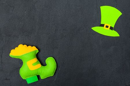 St. Patrick's Day theme colorful horizontal banner. Green leprechaun hat, and shoe with gold on black background. Felt craft elements. Copy space. For greeting card, congratulation banner.の写真素材