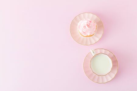 Pink pastel vertical banner with decorated cupcakes, cup of coffe with milk - top view of beautiful sweet dessert for congratulation poster, greeting card for birthday or weddingの写真素材