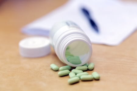 Medicine bottle and pills and note with a penの写真素材